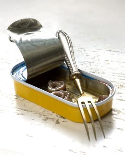 Fork leaning on a can of anchovies