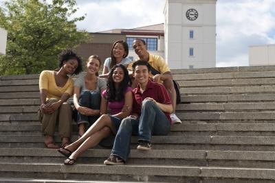 Young students happily sitting outside school.