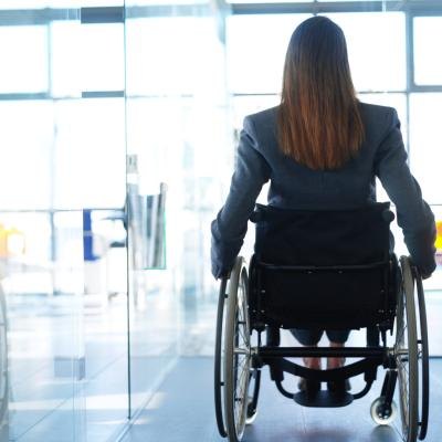 Rearview of a business woman in a wheelchair.