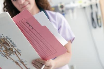 Nurse holding patients chart Nurse looking at chart