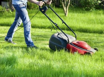 Man with electric lawn mower