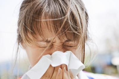 A woman blows her nose outside.