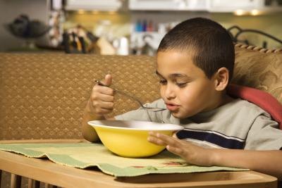 Young boy eating a bowl of soup