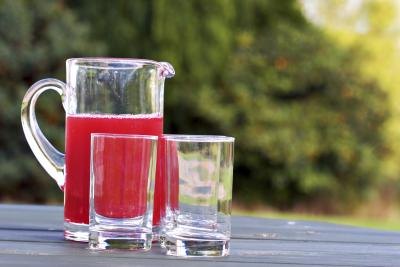 A jug of cranberry juice and drinking glasses