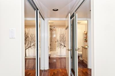 Hallway with mirrored closets leading to bathroom