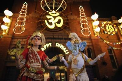 Costumed revelers dressed as Lord Genesha and Goddess Lakshmi during Diwali festival