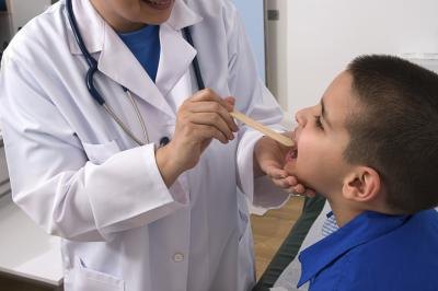 Doctor looks down young boy's throat