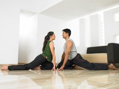Man and woman doing One-Legged Pigeon pose.