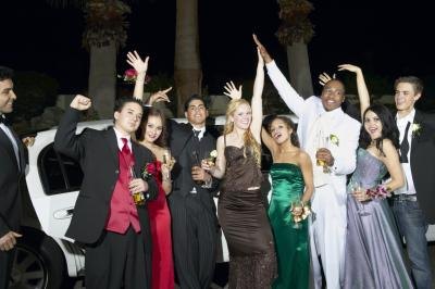 Teenagers stand outside limousine