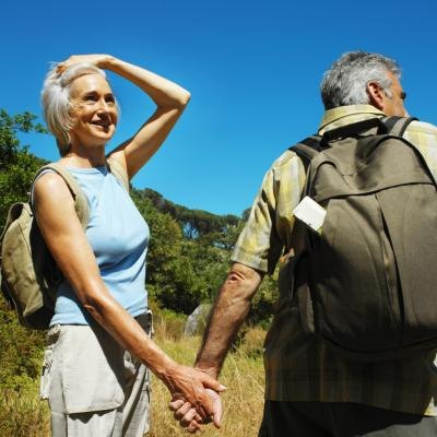 A mature couple takes a hike in the country side.