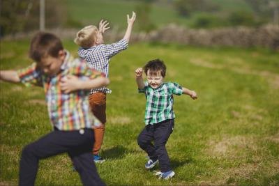 3 young boys dancing outdoors.
