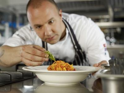 Chef add garnish to entrée
