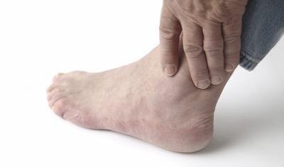 Mature man touches ankle.