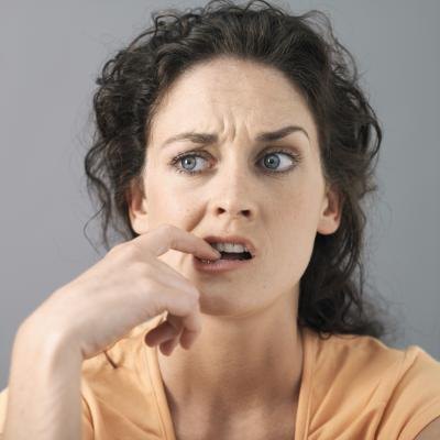 Nervous woman bites her nail.