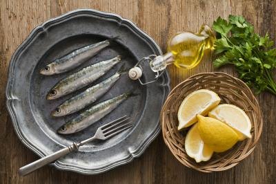 Fresh raw sardines with a side of lemon slices and parsley