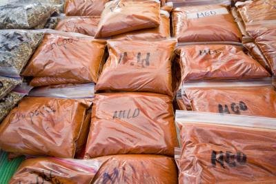 Bags of mild and medium ground chipotle pepper at outdoor market