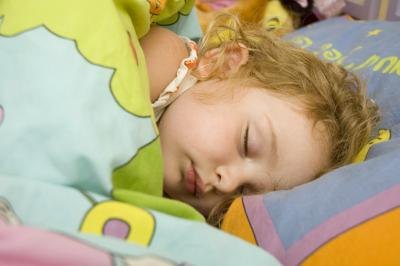 Child sleeps on colorful bedding