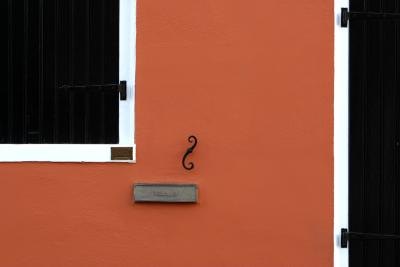 Mail slot on building painted red.