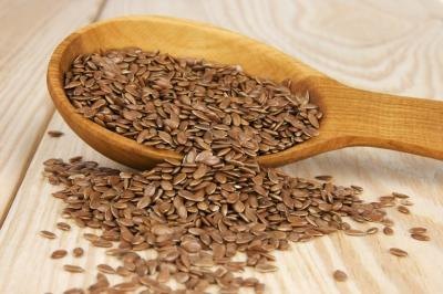 Flaxseed spilling from a wooden spoon