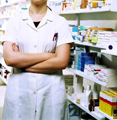 Pharmacist next to shelves of medicine