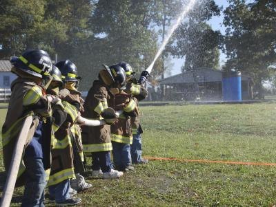 Young children learning how to be firefighters.