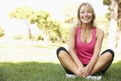 Healthy senior woman stretches in park
