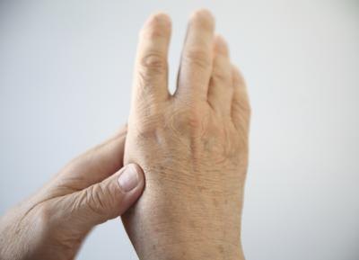 An older woman expieriences arthritis pain in her hand.