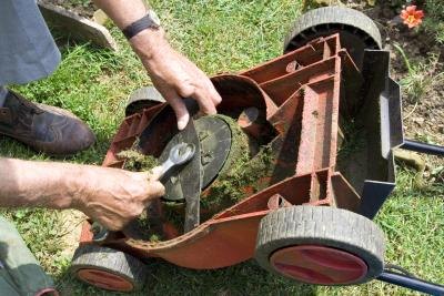 Man adjusting knife on lawnmower to help the governor.