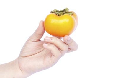 Hand holding a persimmon.