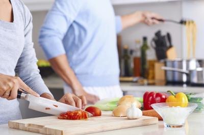 A close up of a couple cooking in a kitchen.