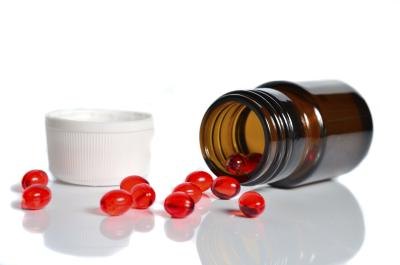 Jar spilling red pills onto tabletop.