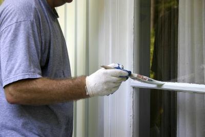 Man putting on finishing coat of paint.
