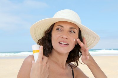 Woman applying sunscreen to the face