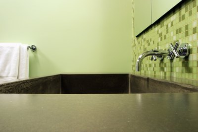 A zen bathtub surrounded by pale green walls.