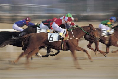 Jockeys on horses in motion during a race.