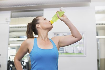 Woman drinking a sports drink at the gym.