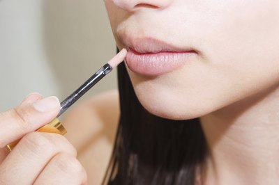 Teen applying lip gloss