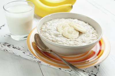 A bowl of oatmeal with sliced bananas on top