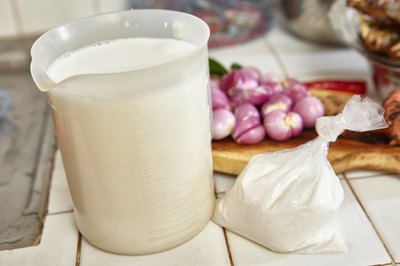 Tall plastic container filled with coconut milk.