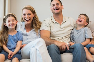 Family laughing on couch