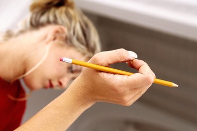 A woman holds a pencil while thinking.