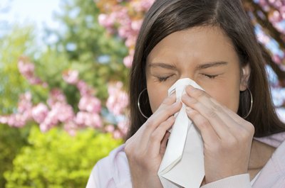 woman sneezing in tissue