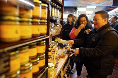 People sample olive oils inside market in Brooklyn, NY.