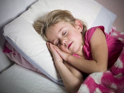 A young girl sleeping in her bed
