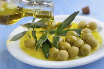 Fresh olive oil being poured into small dish.