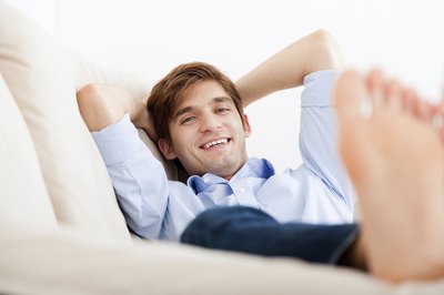 Man elevates his feet on couch