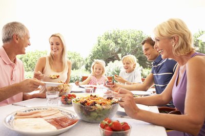 Large family eating lunch outdoors.