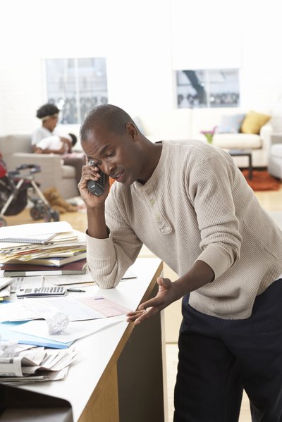 Man talking on the phone with bills