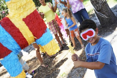 Blindfold young boy trying to hit pinata