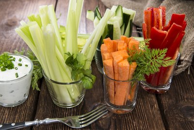 Assorted vegetables in cups on table.